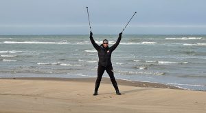 Freya Hoffmeister with arms raised on a beach