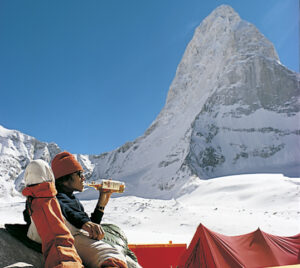A climber in the 1970's sipping whiskey with Changabang in background.