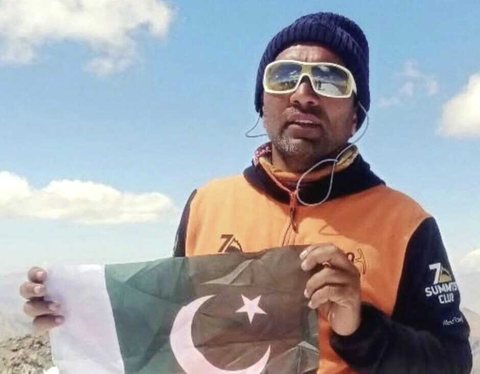 Close shot of Pakistani climber Iftikhar Hussain holding his national flag.