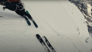 two people on skis looking over a steep descent