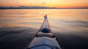 the bow of a kayak at sunset