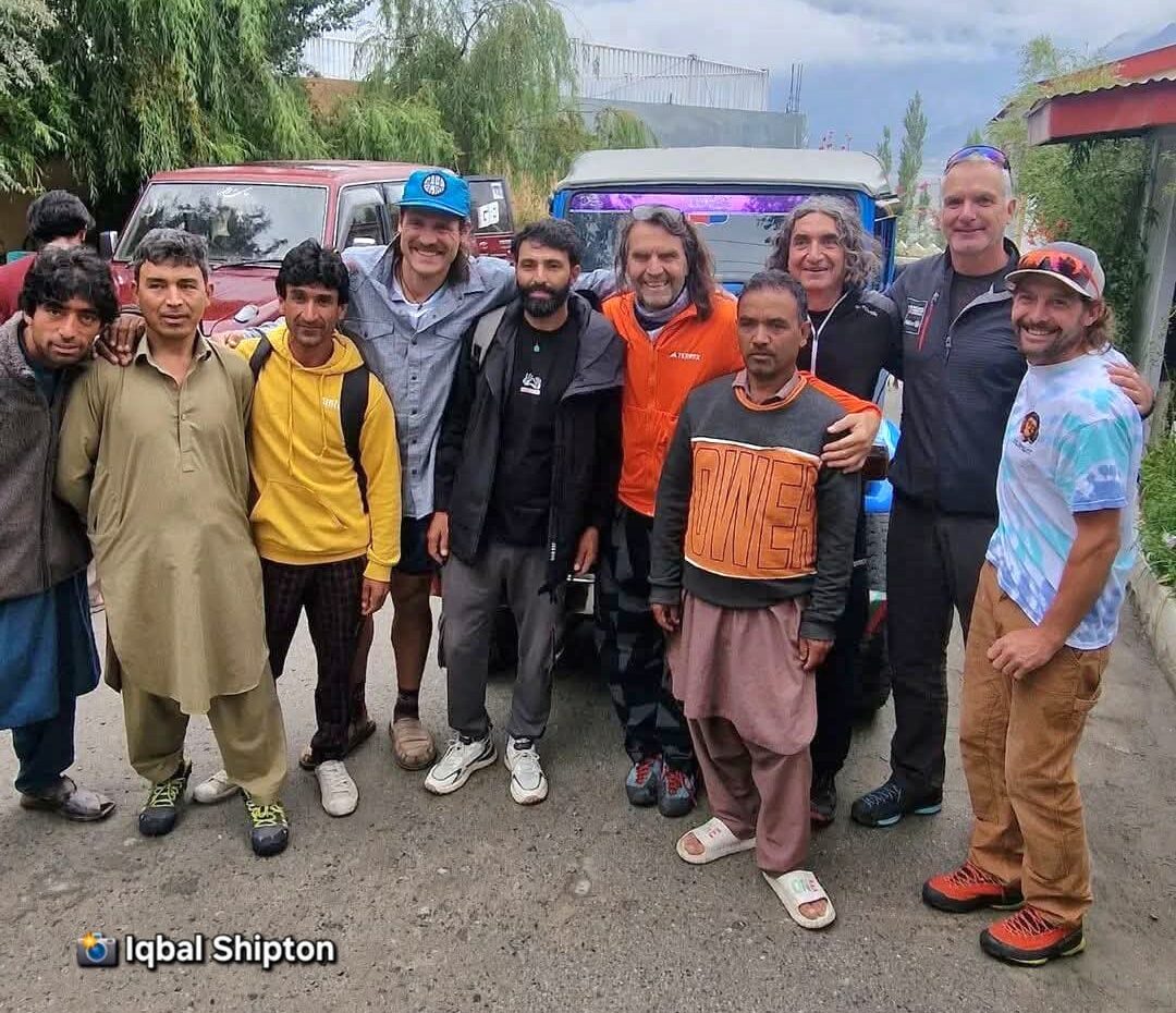 Climbing team with locals in front of 2 vans.
