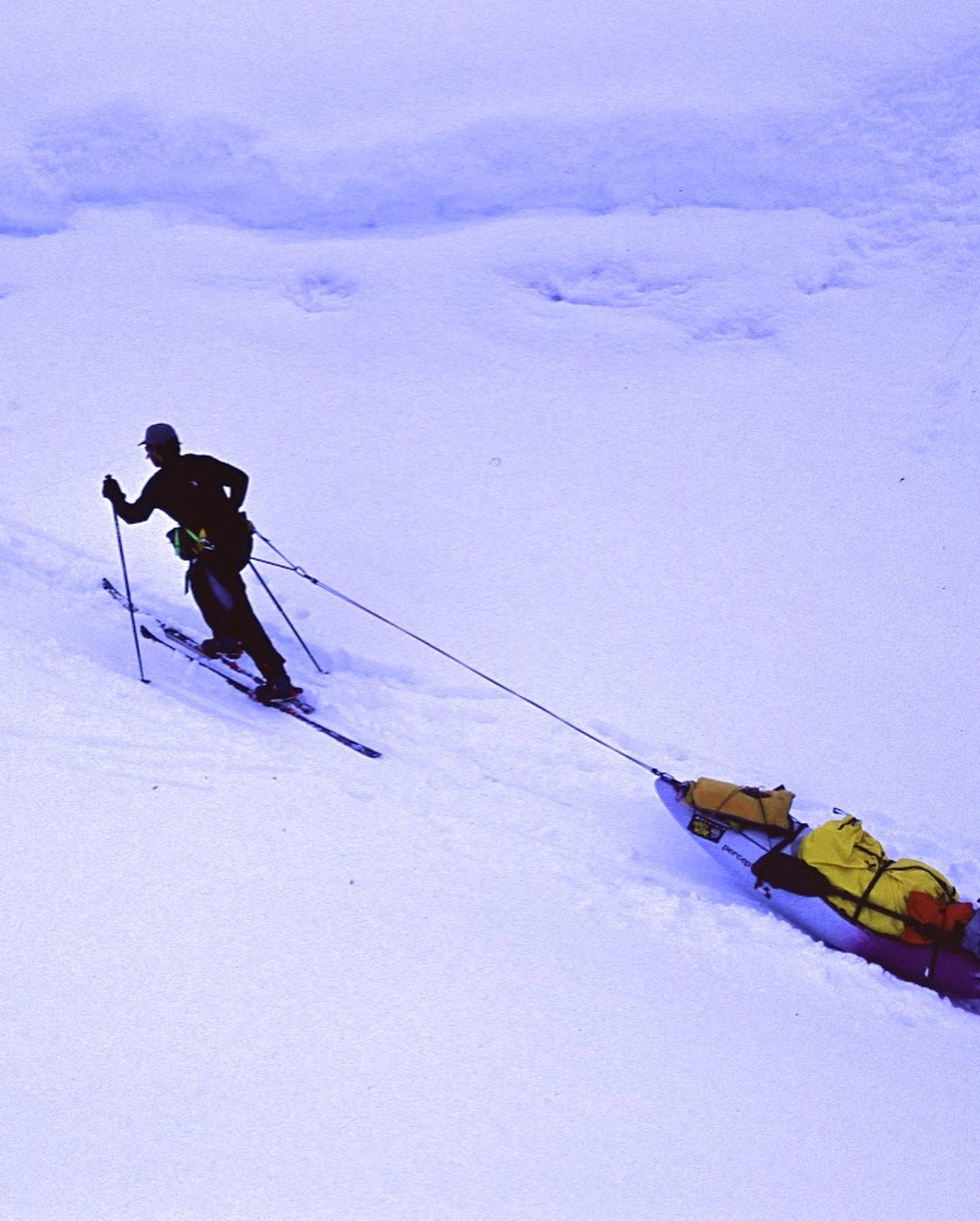 Manhauler drags sled up hill through soft snow
