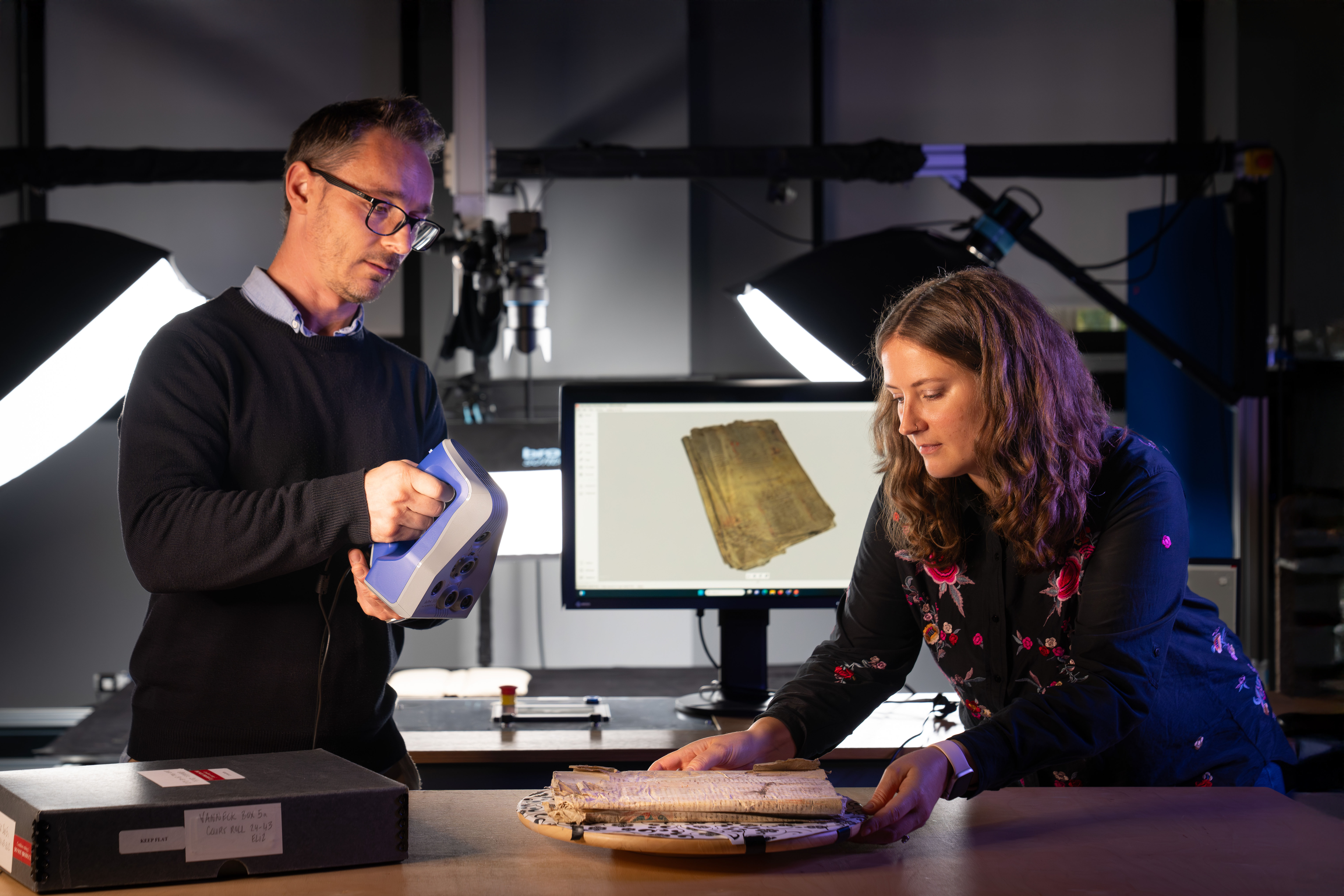 Two people examine an old book.