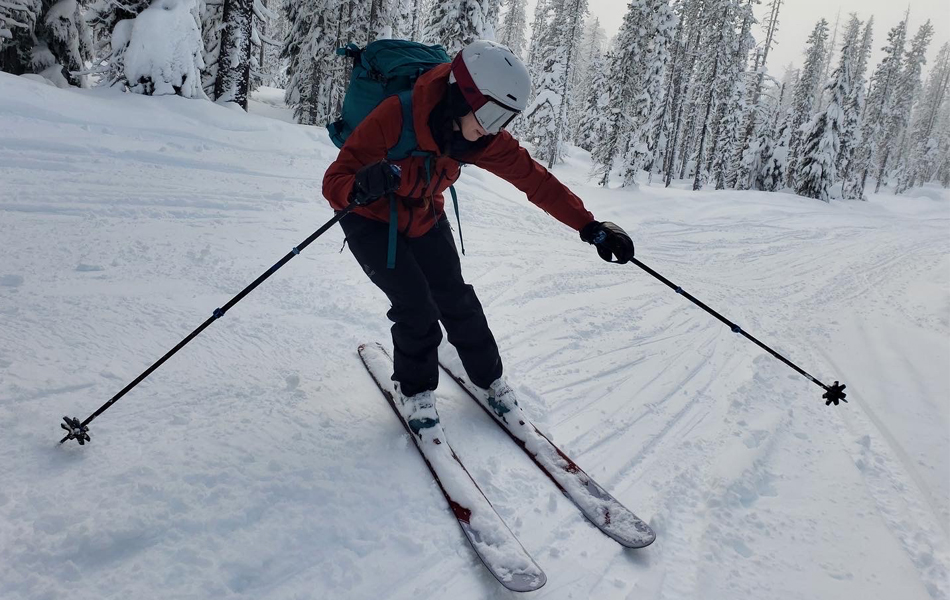 skier with ski poles, helmet, backpack and ski bindings