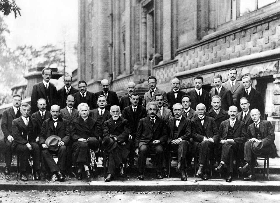 A black and white photograph of people sitting.