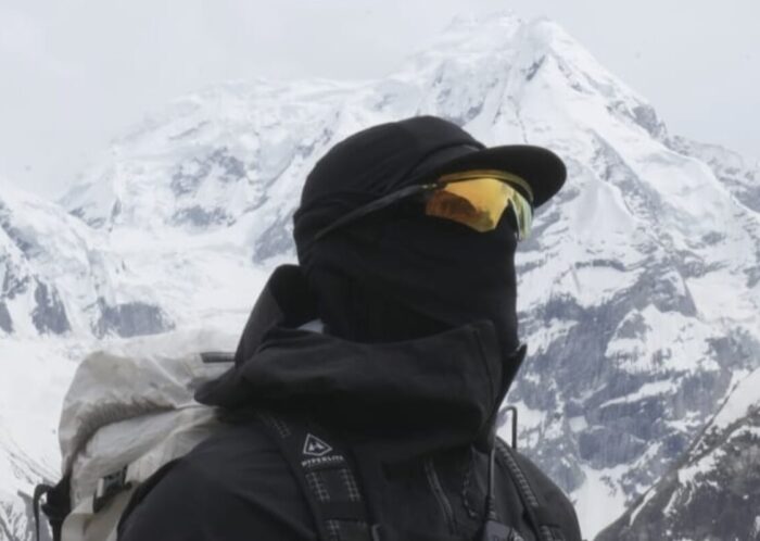 One of the climbers, totally covered by sunglasses and a scarf on the face, with Spantik behind him. 