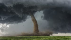A tornado touches down in a green field
