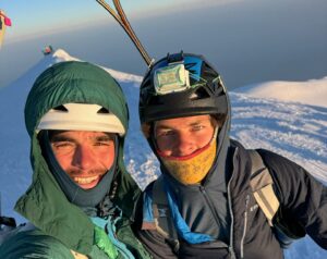 Close shot of Vedrines and Jean with the sunrise light on their faces as they stand in a the snowy summit of Mont Blanc.